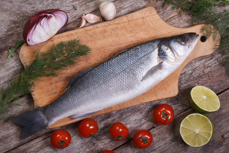 与鱼切菜板与蔬菜的切菜板上的鲈鱼脍鱼顶视图照片