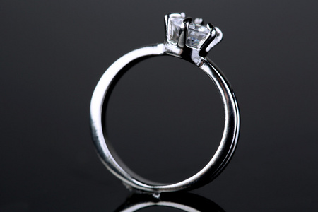 在灰色的背景上的美丽的钻石戒指