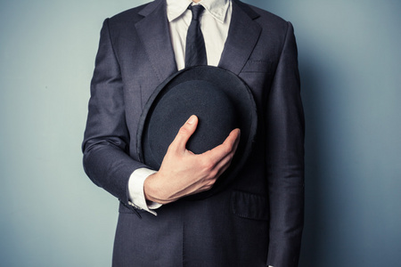 男人抱着一顶圆顶硬礼帽的帽子