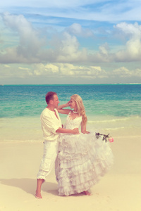 新郎和新娘美丽的热带海滩。，带有复古效果