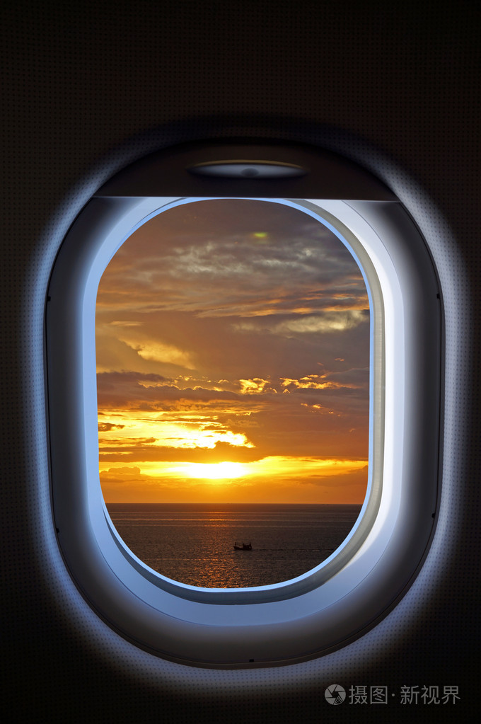 喷气飞机窗口与落日的天空视图