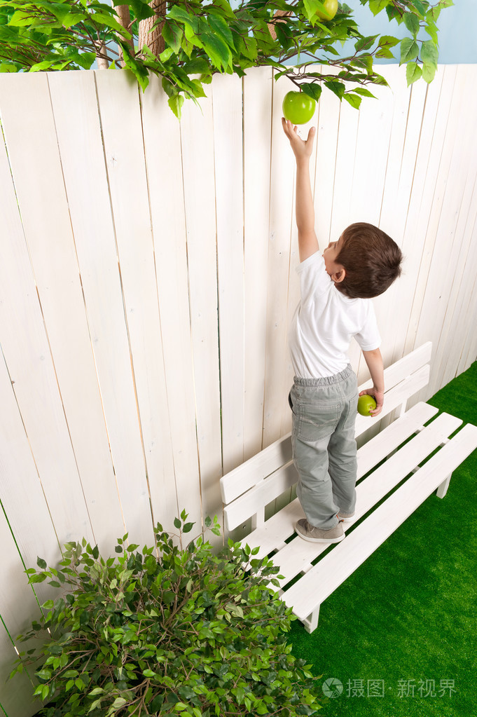 男孩伸手去够苹果
