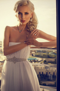在阳台上摆姿势的金发的美丽的新娘