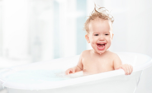 快乐有趣的婴儿笑和沐浴在浴