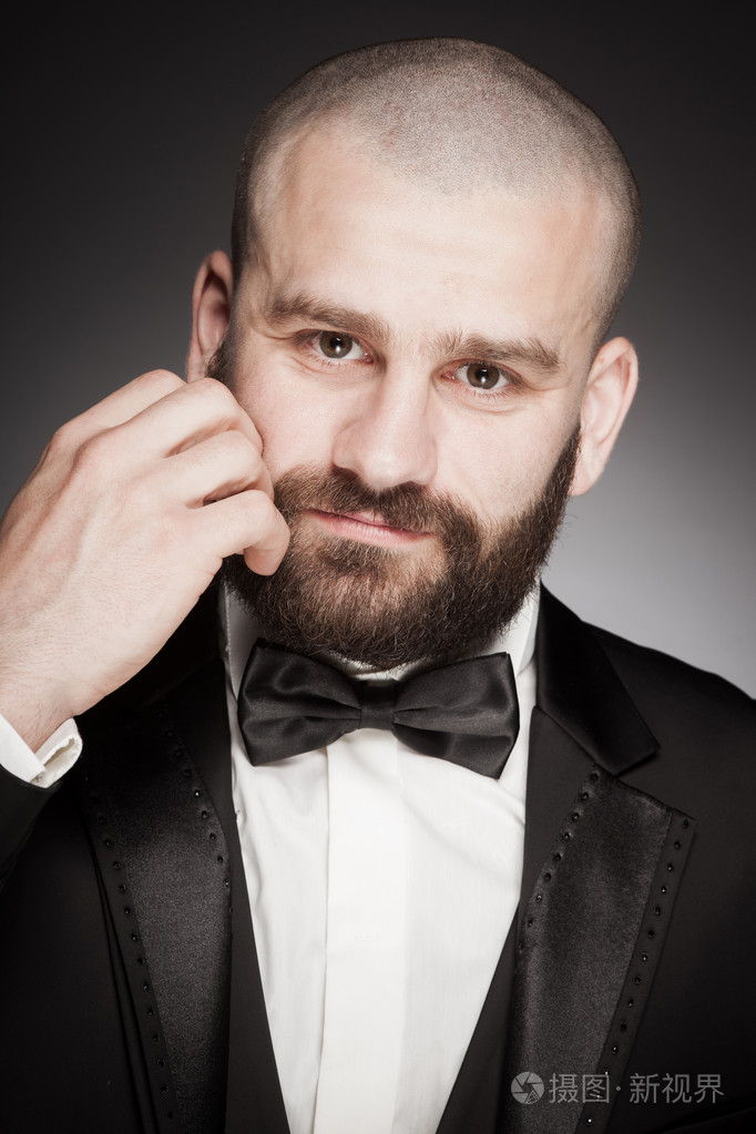 时尚和残酷秃头的男人,留着胡子的优雅的黑色西装