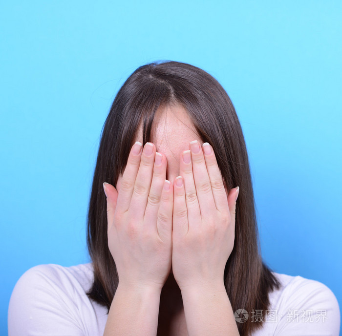 捂着脸用手在蓝色背景下的肖像