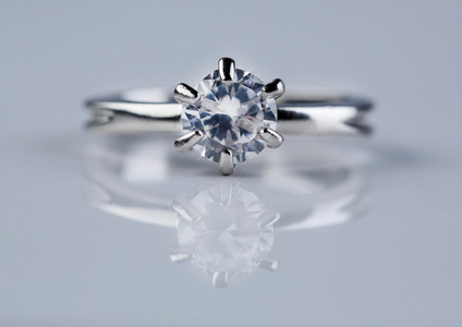 在明亮的背景上的美丽的钻石戒指