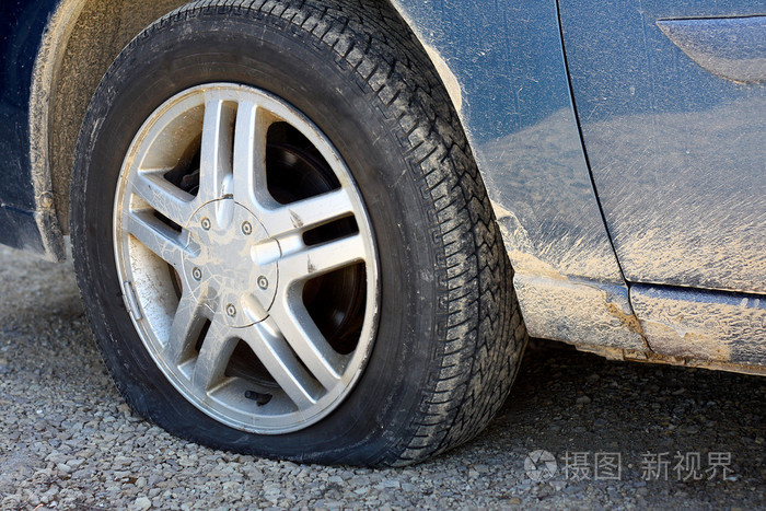 在肮脏的旧车上轮胎漏气