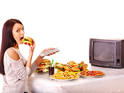 女人吃快餐和看电视