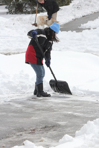 夫人从车道上的铲雪