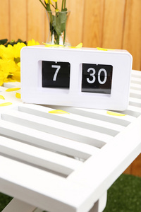 数字闹钟在桌子上，木制的背景上