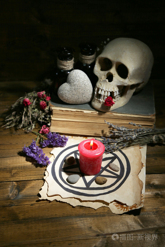 爱情魔法的概念照片与头骨干的香草和黑暗的木背景蜡烛组成