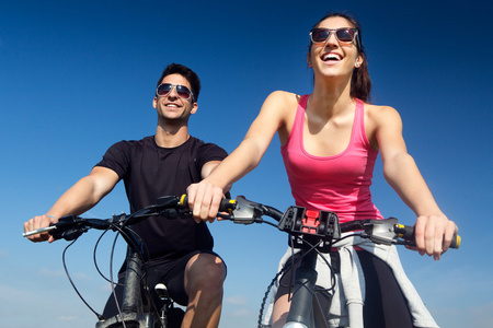 快乐在乡下骑一辆自行车上的年轻夫妇