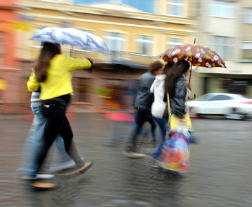 一群人走在街上，在下雨天