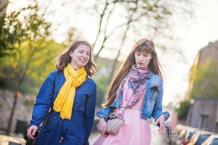 两个漂亮的女孩一起走着,聊天