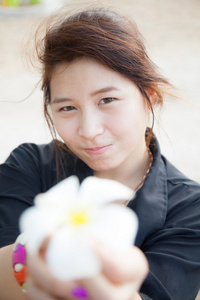 亚洲女性黑衬衫。拿着白花