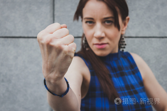 漂亮的女孩,显示她的拳头照片-正版商用图片1ff2as-摄图新视界