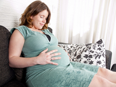 怀孕的年轻女子在沙发上休息