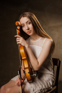 美丽的年轻女子在黑拉小提琴