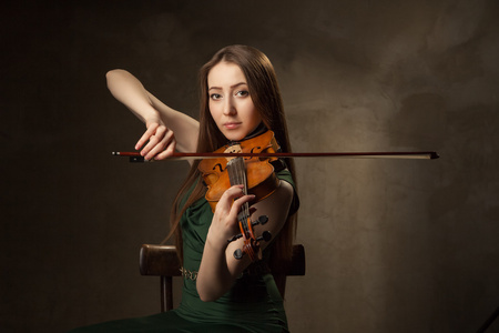 美丽的年轻女子在黑拉小提琴