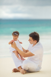 快乐的父亲和他的小女儿在海滩上
