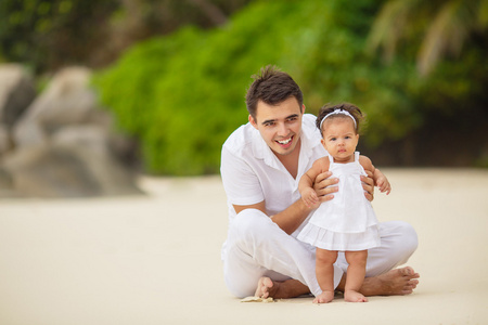 快乐的父亲和他的小女儿在海滩上