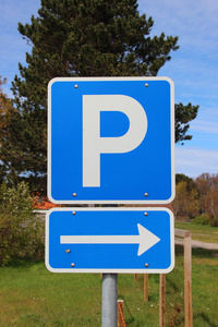 蓝色的停车场标志与右箭头和背景中的天空