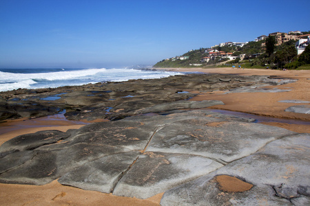 干燥裸露的岩石在退潮的海滩上