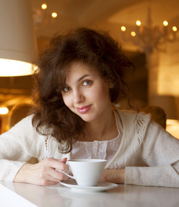 年轻女人享受拿铁咖啡在咖啡厅