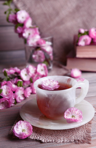 美丽的果实花朵以杯茶上灰色背景表格