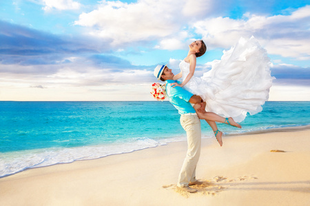 幸福的新娘和新郎在地处热带的海滩上尽情的