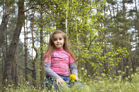 在树林里坐在一个树桩上的女孩