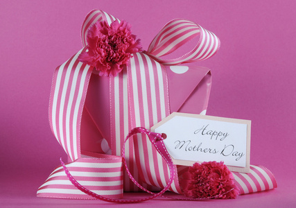 幸福的母亲一天蛋糕礼物在粉红色的背景上