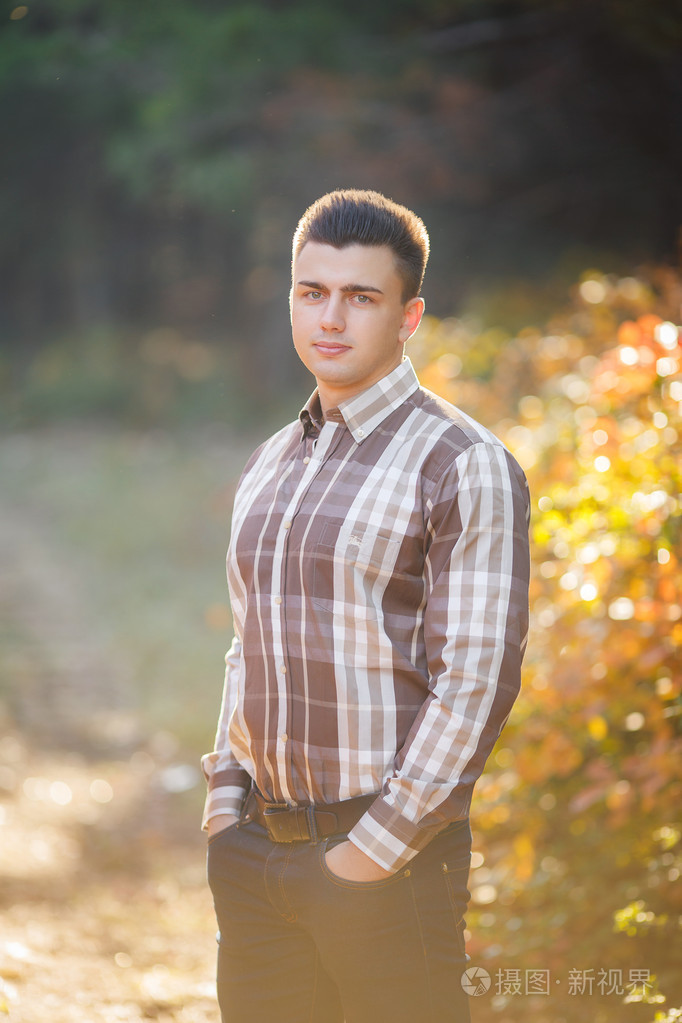 在秋天的公园里的漂亮的男人的肖像