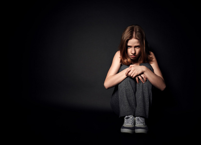 在抑郁和绝望在黑黑暗哭泣的女人照片