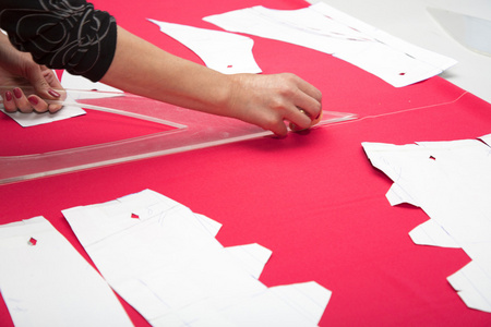 裁缝手使用粉红色织布。