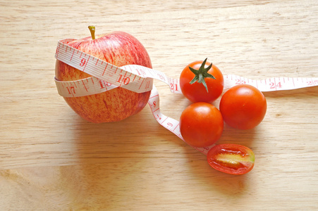 用卷尺和西红柿包装红苹果饮食概念