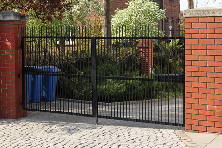 没有坚固的栅栏. 铁门. 有柱子的栅栏. 金属锻造铁格栅和栅栏的院子.