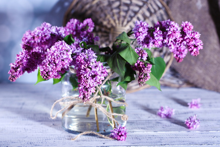 美丽的淡紫色花，插在花瓶里，颜色木制的桌子，在明亮的背景上