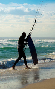 风筝冲浪。kitesurfer 与 kiteboard 在海滩散步