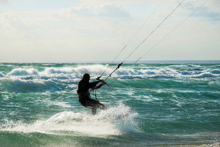 风筝冲浪。kitesurfer 在日落时分破浪前进