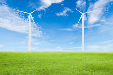 在蓝蓝的天空和绿色草地上的风力发电机组