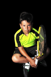 英俊的男孩，与网球设备的肖像