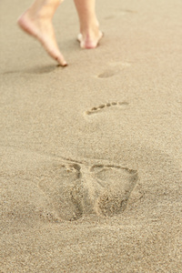 女孩在沙子里留下足迹