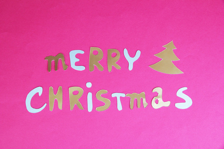 在粉红色的背景上的快乐圣诞刻字。