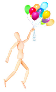 抱着飞行的气球，孤立的木制娃娃