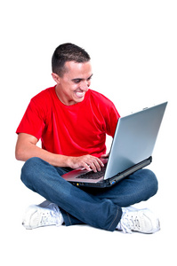 十几岁的男孩坐在地板上与计算机
