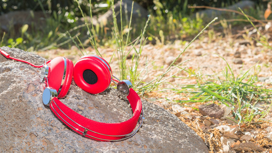 鲜艳的红色有线耳机在石头上