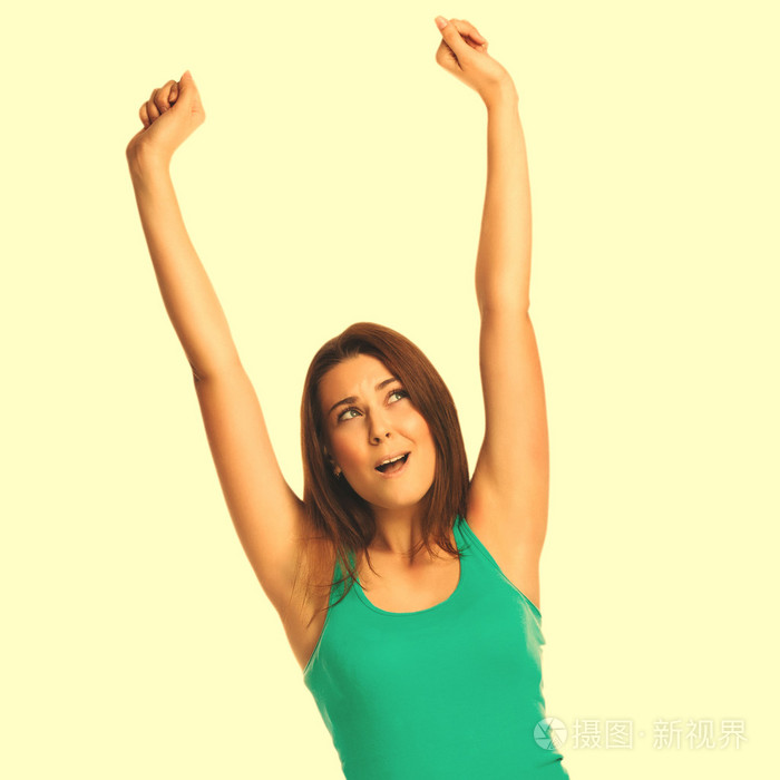 漂亮的女人举起双手一件背心的快乐成功看起来