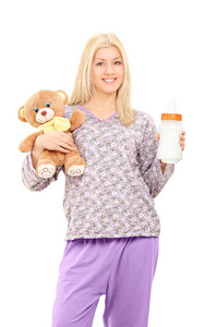 女人穿着睡衣，抱着玩具熊